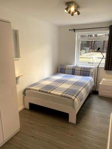 a small bedroom with a bed and a window at National Arena, free Parking in Nottingham