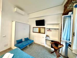 a room with a blue couch and a tv at The Vernazza Main Plaza - Rooms & Apartment in Vernazza