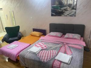 a bedroom with a large bed with pink sheets and bows at Impressive Apartment in Nikšić