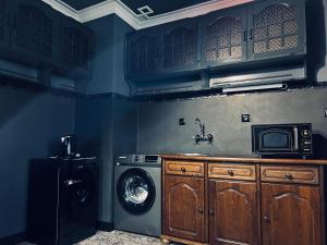 a laundry room with a washing machine and a microwave at Central Apartment Black Cat in Karlovo