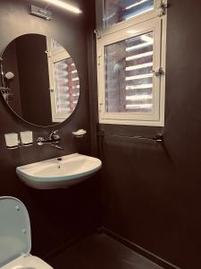 a bathroom with a sink and a mirror and a toilet at Central Apartment Black Cat in Karlovo +19 photos