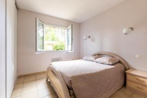 1 dormitorio con cama y ventana en Vacances apaisantes au coeur du Bassin d Arcachon, en Lanton