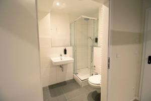 La salle de bains blanche est pourvue de toilettes et d'un lavabo. dans l'établissement Diamonds Hotel, à Cologne