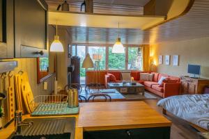 uma cozinha e sala de estar com um sofá e uma mesa em Cosy studio on the ski slopes em Gryon