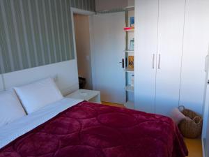 um quarto com uma cama com um cobertor roxo em Apto aconchegante ao lado da Vinícola Garibaldi em Garibaldi
