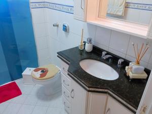 een badkamer met een wastafel en een toilet bij Apto aconchegante ao lado da Vinícola Garibaldi in Garibaldi