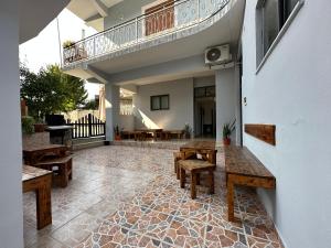 een patio met houten banken en een balkon bij Hannas Hostel in Berat