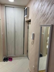 een badkamer met een deur en een spiegel en roze schoenen bij Impressive Apartment in Nikšić