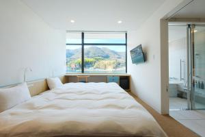 a bedroom with a large bed with a large window at BONAPOOL in Onomichi