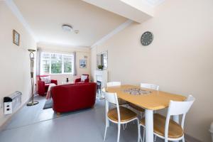 a dining room with a table and a red couch at Charming 2 Bed Apartment - 5mins to Aviva stadium in Dublin