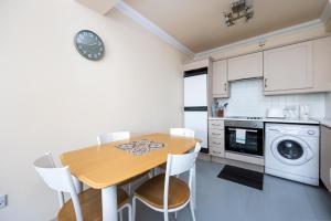 a kitchen with a wooden table and white cabinets at Charming 2 Bed Apartment - 5mins to Aviva stadium in Dublin
