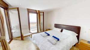 ein Schlafzimmer mit einem Bett mit zwei Kissen und einem Spiegel in der Unterkunft Fine Duplex Apartment with Stunning Sea Views in Marbella + 22 Fotos