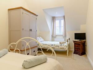 a bedroom with two beds and a cabinet and a television at 5 Bed in Glastonbury 91657 in Meare