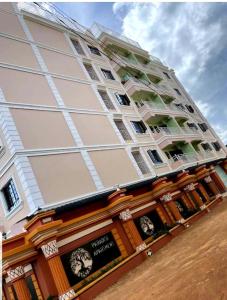 un grande edificio con un orologio sul lato di T-Tree Paradise Apartments a Embu