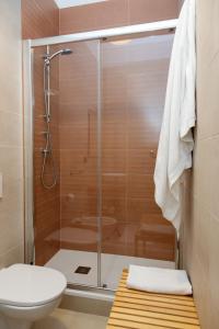 La salle de bains est pourvue d'une douche en verre et de toilettes. dans l'établissement ApuliaLux Prana Home - Bari City Center, à Bari