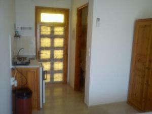 a room with a kitchen with a door and a counter at Sofos Apartments in Tsilivi +21 photos