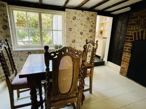 The Old Smoke House في Kent: غرفة طعام مع طاولة وكراسي خشبية