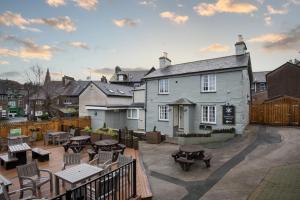 an outdoor patio with tables and chairs and a building at The Temperance Inn, Ambleside - The Inn Collection Group in Ambleside