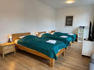 três camas num quarto com lençóis verdes em 3 Rooms, free Parking, 25 min to Düsseldorf, 200 Mbps WLAN em Duisburg