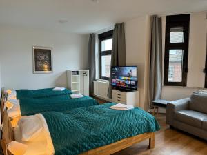 um quarto com 2 camas, um sofá e uma televisão em 3 Rooms, free Parking, 25 min to Düsseldorf, 200 Mbps WLAN em Duisburg