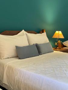 Bichinho的住宿－Pousada Prana Bichinho，一张带两个枕头的白色床和蓝色的墙壁