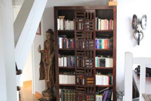 a book shelf filled with books next to a statue at Modern Villa With Swimming Pool Lake Access in Nernier