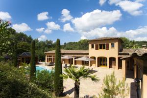 a large house with a swimming pool and trees at Domaine Les Cigales in Mouans-Sartoux