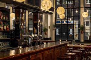 eine Bar mit Holztischen und -stühlen in einem Zimmer in der Unterkunft Renaissance Amsterdam Hotel in Amsterdam