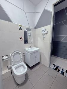 a bathroom with a toilet and a sink at Doyar's Home Stay (Palm Garden -1st Floor) in Lahad Datu