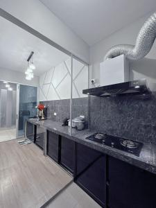 a kitchen with a counter top and a stove at Doyar's Home Stay (Palm Garden -1st Floor) in Lahad Datu