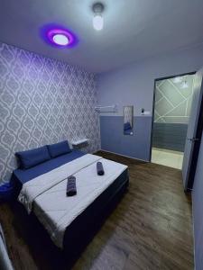 a bedroom with a large bed with a purple ceiling at Doyar's Home Stay (Palm Garden -1st Floor) in Lahad Datu