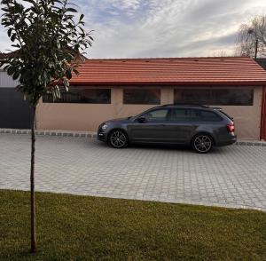 un coche aparcado frente a una casa en B-HAUSE zárt parkolóval és jacuzzival, en Debrecen
