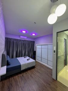 ein Schlafzimmer mit einem Bett und lila Wänden und lila Lichtern in der Unterkunft Doyar's Home Stay (Palm Garden -1st Floor) in Lahad Datu