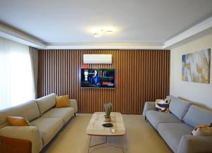 BlueHomes Villas في بيليك: غرفة معيشة مع أريكة وتلفزيون