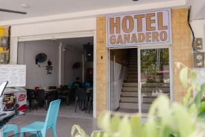 HOTEL GANADERO في لا دورادا: مطعم مع علامة كاماندرو الفندق والطاولات والكراسي