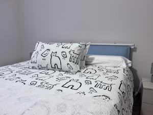 uma cama com lençóis e almofadas preto e branco em Casa Piemont em Casale Monferrato