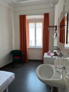 a white bathroom with a sink and a window at Casa Da Vinci B&B in Locarno