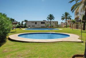 una grande piscina in un cortile con palme di Fine Duplex Apartment with Stunning Sea Views a Marbella
