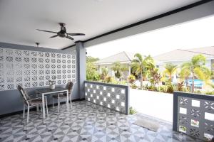 patio con mesa y sillas y balcón en MB House Resort en Ban Nai Rai