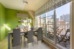 uma sala de jantar com paredes verdes e uma mesa e cadeiras em Modern duplex apartment near the beach em Middelkerke