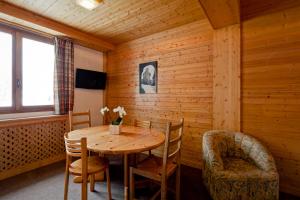 a wooden dining room with a table and chairs at Hotel les Flocons in Courchevel