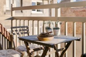una mesa de madera con 2 macetas en el balcón en Modern duplex apartment near the beach en Middelkerke