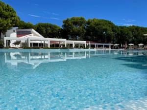 une grande piscine d'eau en face d'un bâtiment dans l'établissement Dei Fiori Camping Village, à Cavallino-Treporti