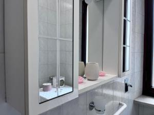 a white bathroom with a mirror and a sink at Casa Piemont in Casale Monferrato