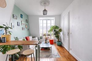 a living room with a table and some plants at Résidor - Charming Apartment T2 in Paris