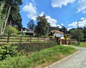a house with a fence and a yard at Recanto Boreal - Monte Verde in Monte Verde