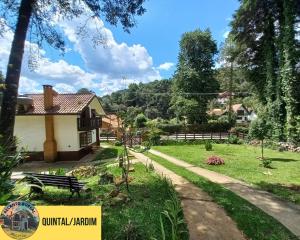 a garden with a house and a path at Recanto Boreal - Monte Verde in Monte Verde