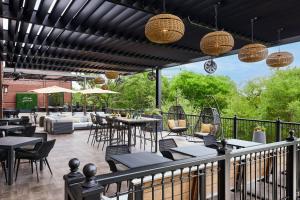 eine Terrasse mit Tischen, Stühlen und Lampen in der Unterkunft Renaissance Austin Hotel in Austin