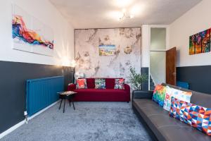a living room with a couch and a red sofa at 6 Roomy Bedrooms Favour Spacious Inn - Sleeps 13 Hull Central Location in Hull