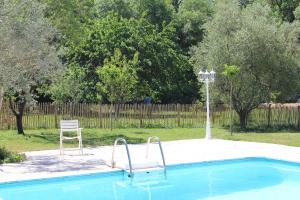 a swimming pool with a chair next to a chair at Bastide provençale avec piscine in Brignoles